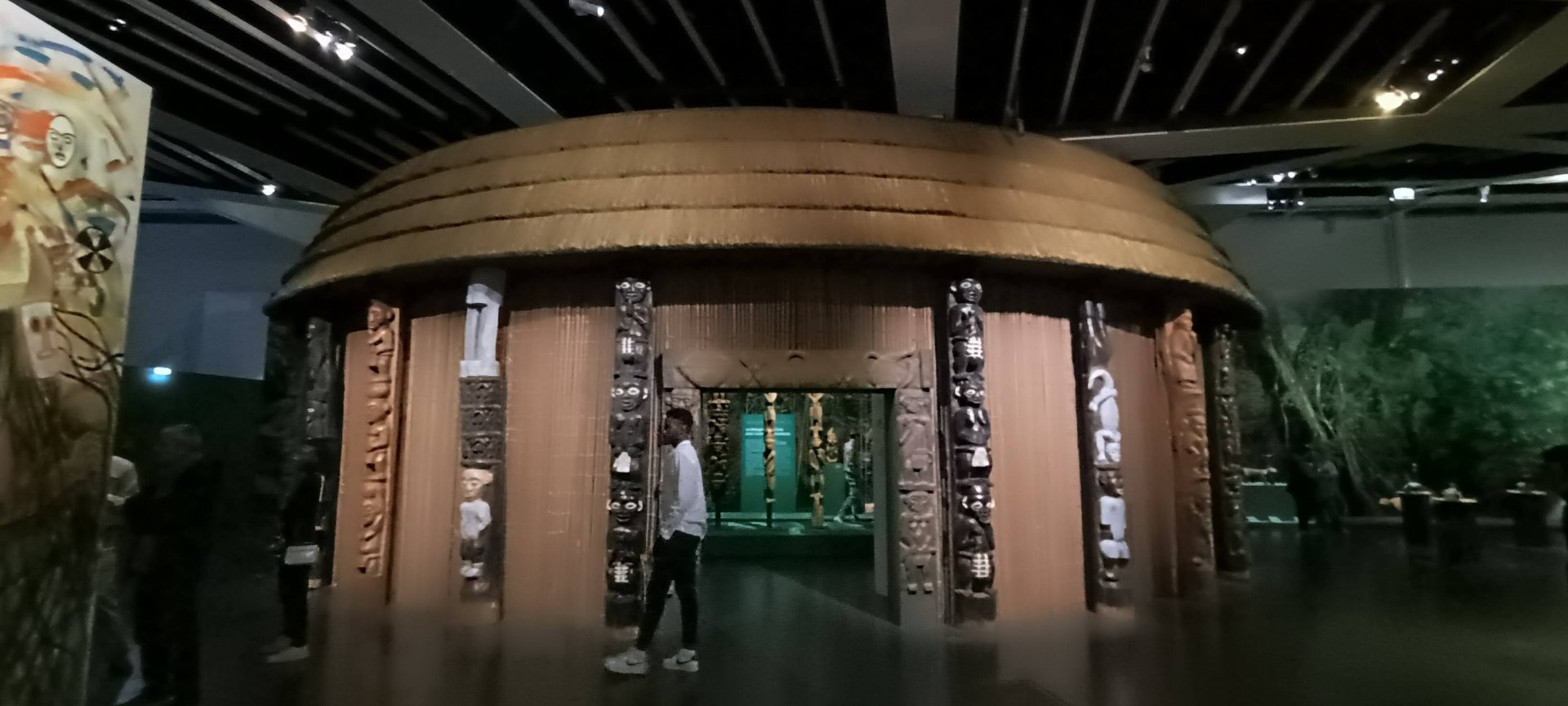 Case royale Bamiléké reconstituée avec ses poteaux sculptés et son toit de chaume