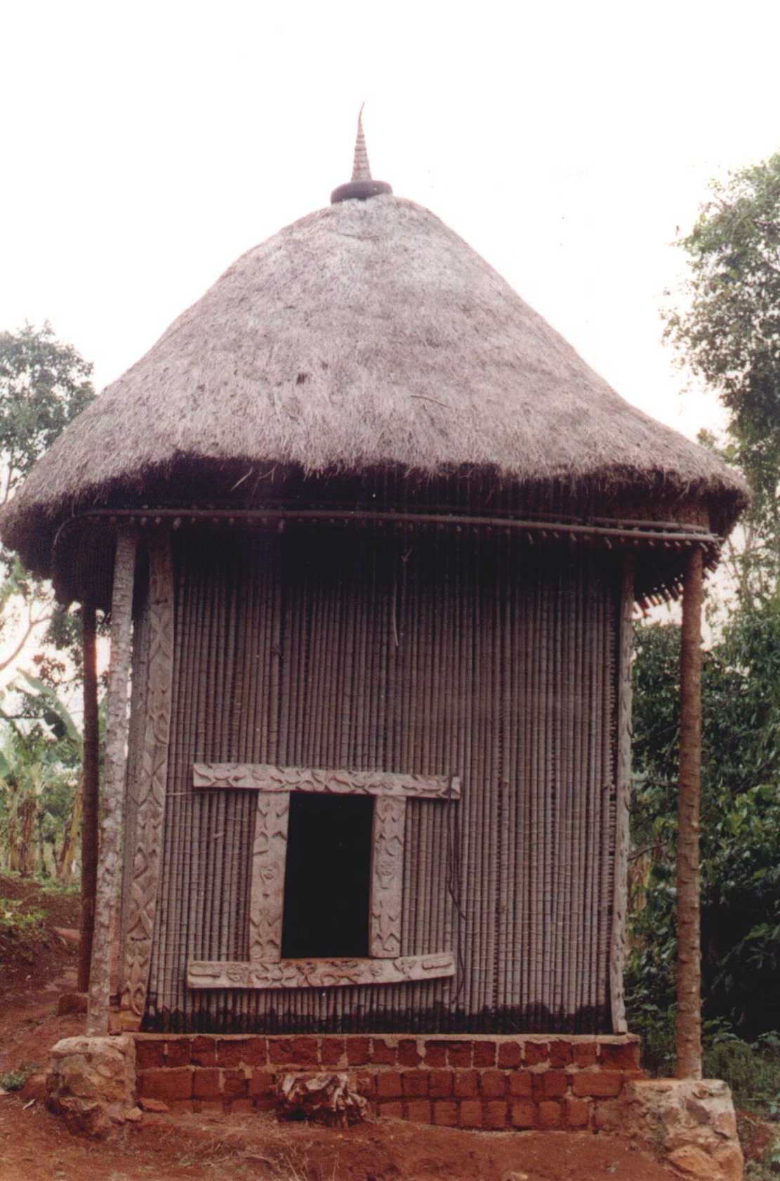 Case sacrée à façade sculptée et toit conique