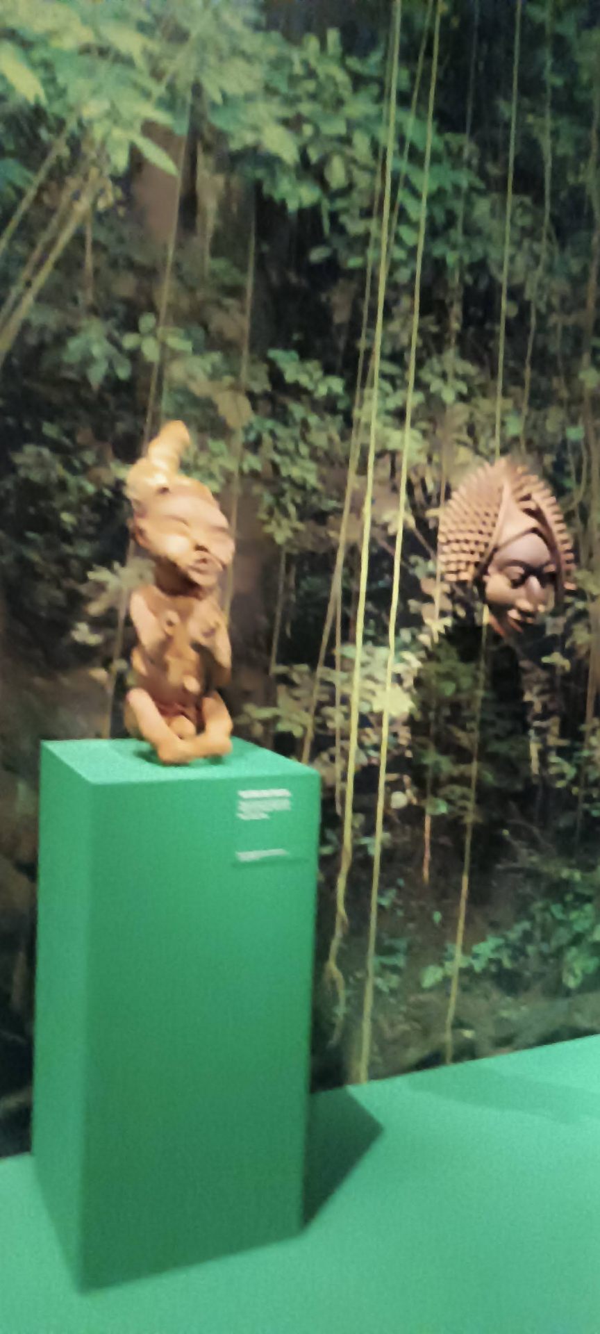 Statuettes anthropomorphes en terre cuite devant un décor forestier